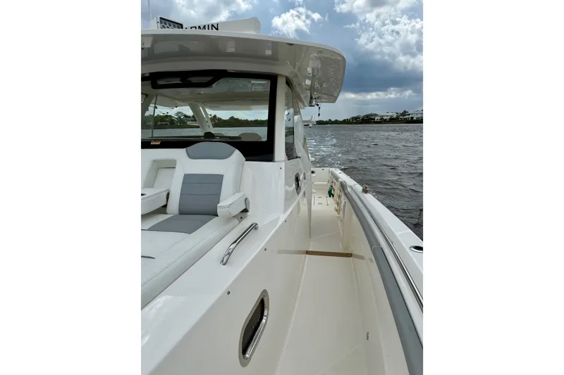 Slide: The Image of 2020 Pursuit S 408 Sport boat on water, showcasing sleek design and spacious deck. - 18