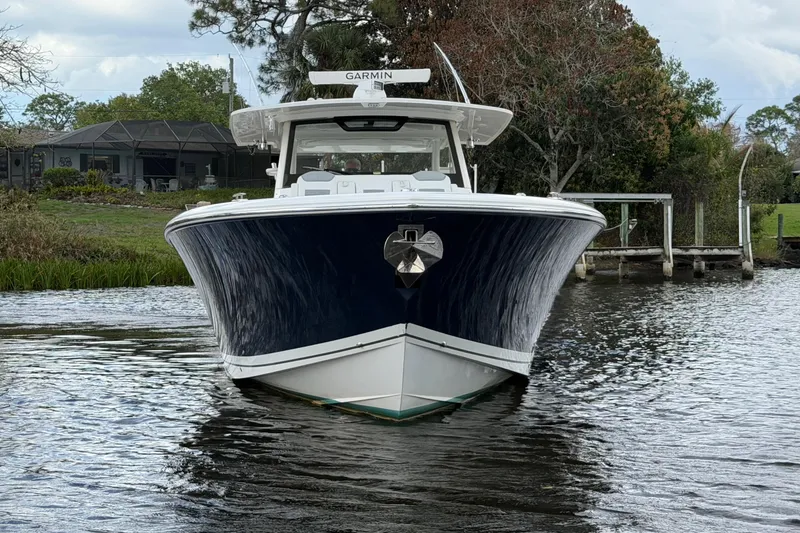 Slide: The Image of 2020 Pursuit S 408 Sport boat on calm water near a dock. - 2