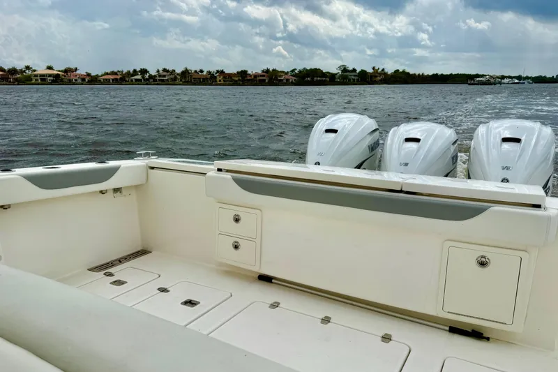 Slide: The Image of 2020 Pursuit S 408 Sport boat with triple Yamaha engines on a calm waterway. - 20