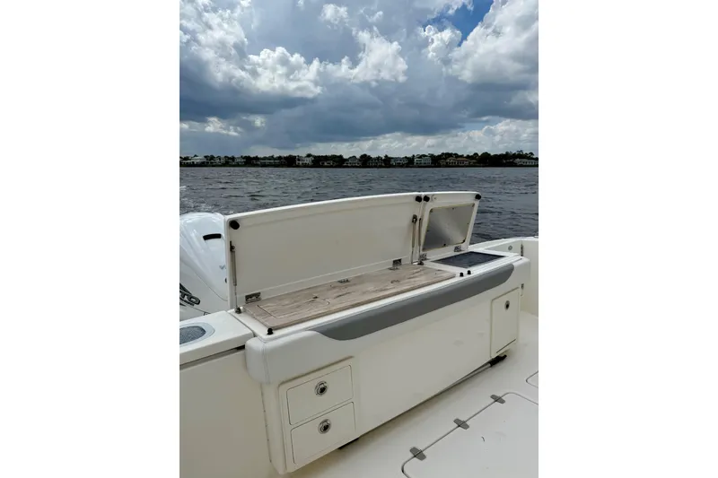 Slide: The Image of 2020 Pursuit S 408 Sport boat with open storage compartment on a cloudy day. - 22