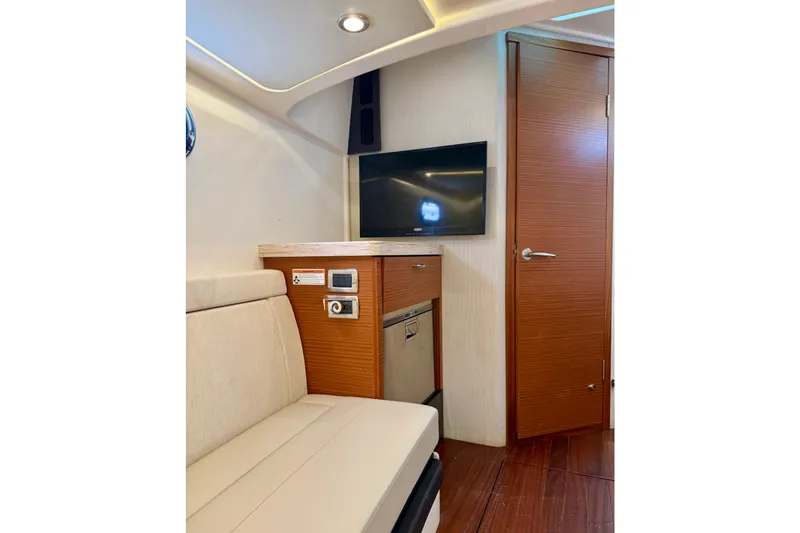 Slide: The Image of Interior of 2020 Pursuit S 408 Sport boat with TV, seating, and wooden cabinetry. - 27