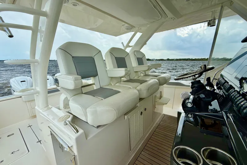 Slide: The Image of 2020 Pursuit S 408 Sport boat interior with luxurious seating and helm controls. - 7
