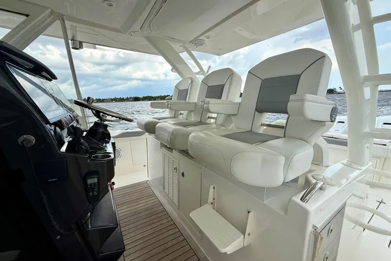 Slide: The Image of 2020 Pursuit S 408 Sport boat interior with helm and seating, overlooking water. - 8