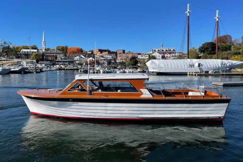 The Image of 1967 Lyman Islander 30 boat on calm water, scenic harbor background. - 0