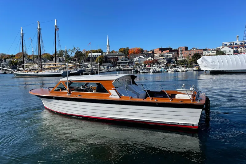 Slide: The Image of 1967 Lyman Islander 30 boat on calm water, scenic harbor background. - 2