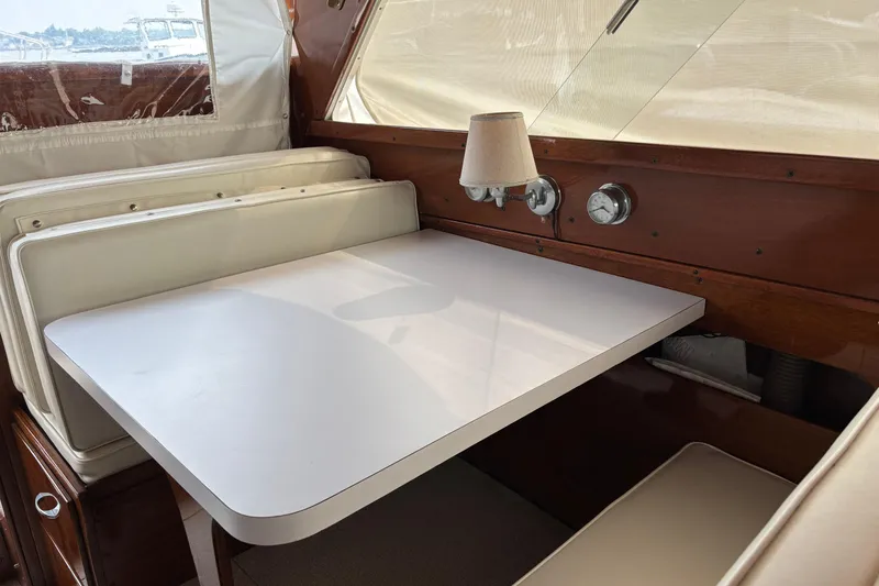 Slide: The Image of Interior of a 1967 Lyman Islander 30 boat with a white table and cushioned seating. - 20