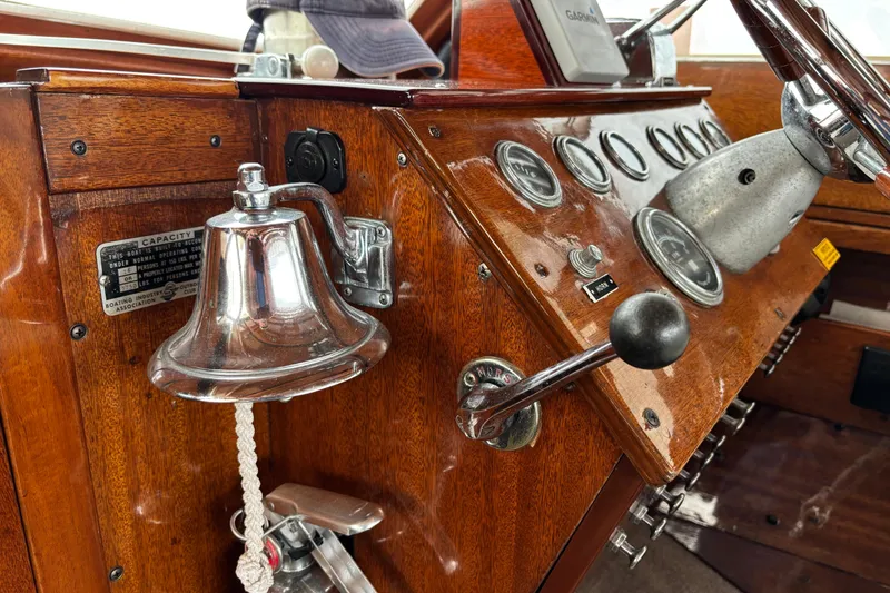 Slide: The Image of 1967 Lyman Islander 30 boat dashboard with gauges, controls, and a polished bell. - 25