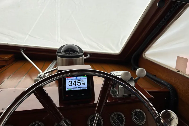 Slide: The Image of 1967 Lyman Islander 30 boat helm with compass and navigation display showing 345 degrees. - 26