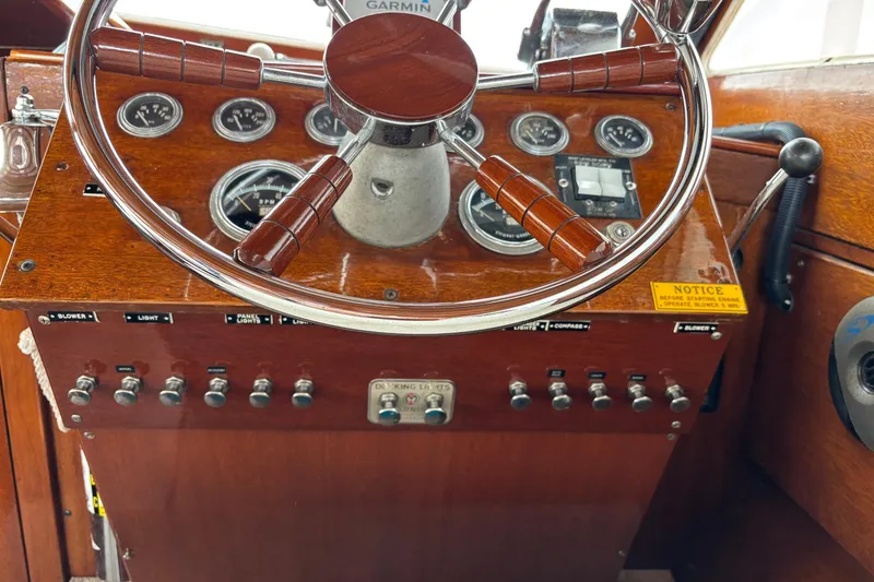 Slide: The Image of 1967 Lyman Islander 30 boat dashboard with wooden steering wheel and control panel. - 27