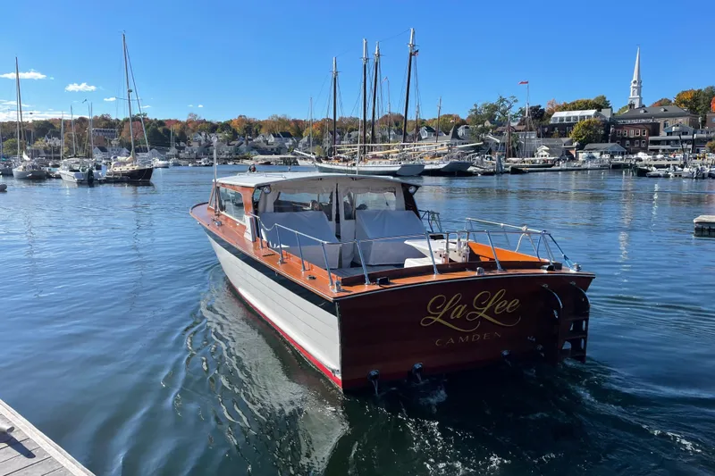 Slide: The Image of 1967 Lyman Islander 30 boat named "La Lee" in a scenic harbor setting. - 3