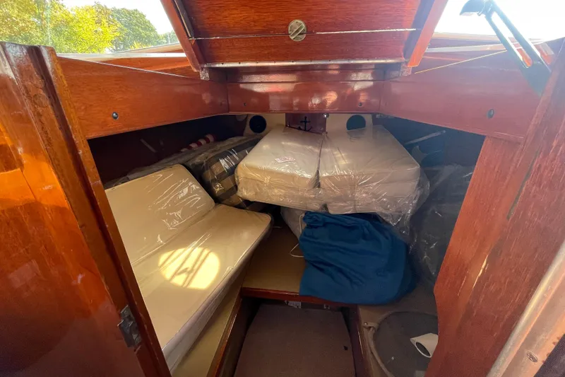 Slide: The Image of 1967 Lyman Islander 30 cabin interior with wooden finish and cushioned seating. - 30