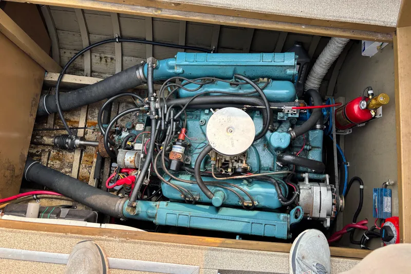 Slide: The Image of Engine compartment of a 1967 Lyman Islander 30 boat, featuring a blue marine engine. - 33