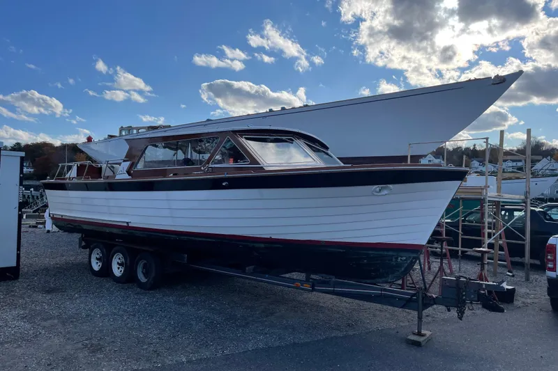 Slide: The Image of 1967 Lyman Islander 30 boat on trailer under blue sky with clouds. - 42