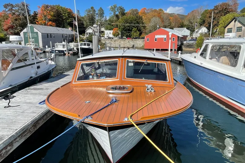 Slide: The Image of 1967 Lyman Islander 30 boat docked in a scenic marina with autumn foliage. - 6