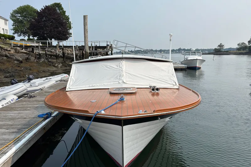 Slide: The Image of 1967 Lyman Islander 30 boat docked by a wooden pier, calm waters in the background. - 9