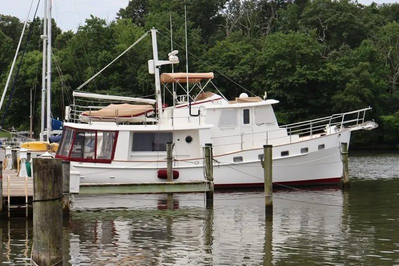 The Image of 2005 Kadey-Krogen 44 yacht docked by lush green trees. - 0