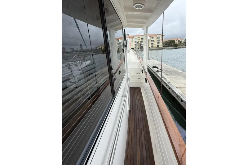 Slide: The Image of 2005 Kadey-Krogen 44 yacht side deck with wooden flooring, docked at marina. - 10
