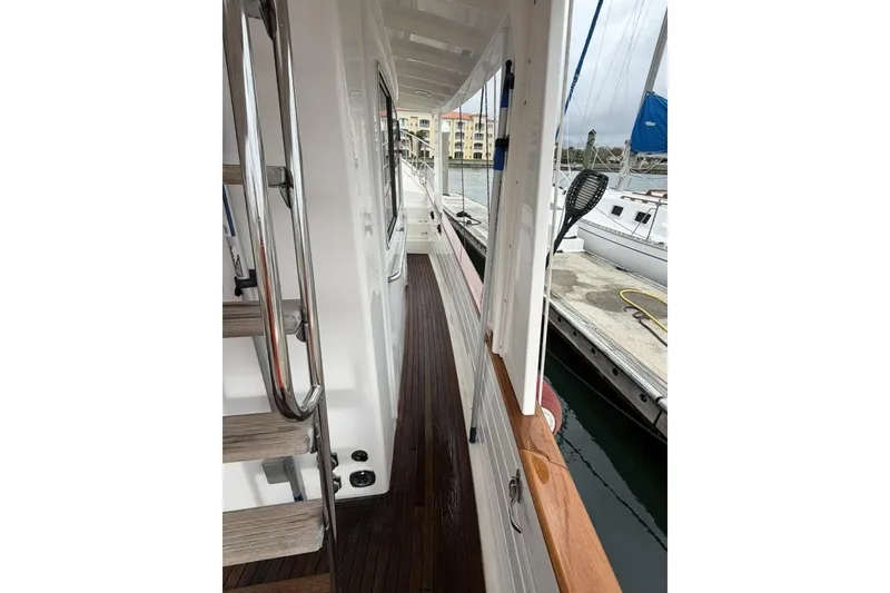 Slide: The Image of Side deck view of 2005 Kadey-Krogen 44 yacht, featuring wooden flooring and stainless steel railings. - 11