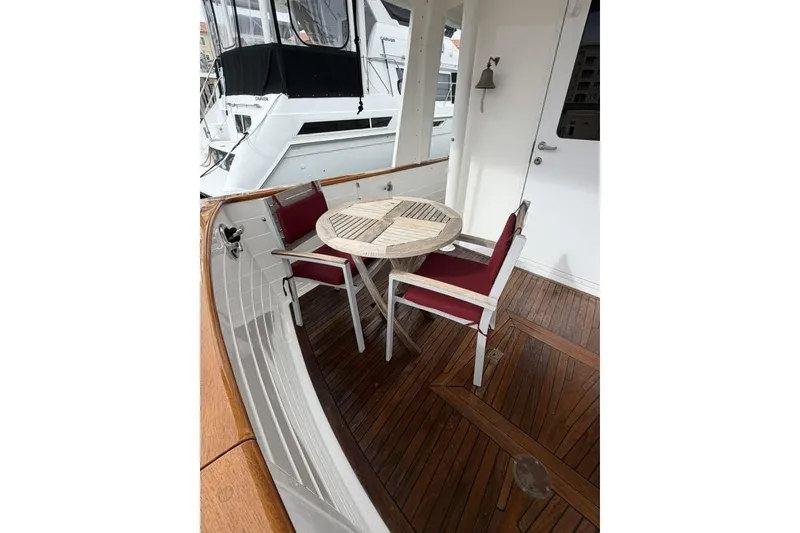 Slide: The Image of Cozy deck seating on 2005 Kadey-Krogen 44 yacht with wooden table and chairs. - 14