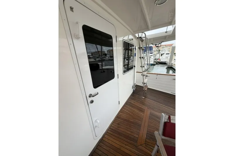 Slide: The Image of 2005 Kadey-Krogen 44 yacht deck with wooden flooring and white door. - 15