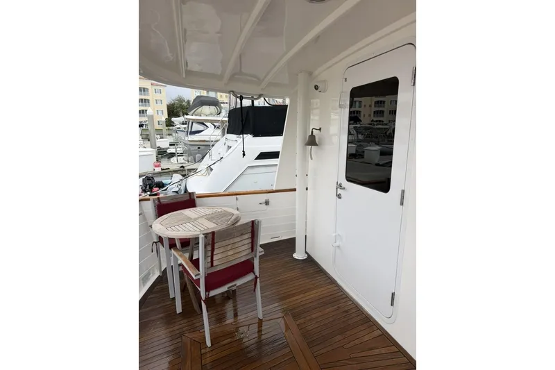 Slide: The Image of 2005 Kadey-Krogen 44 yacht deck with table and chairs, featuring wooden flooring. - 16