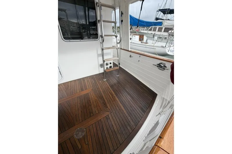 Slide: The Image of 2005 Kadey-Krogen 44 yacht deck with wooden flooring and ladder. - 17