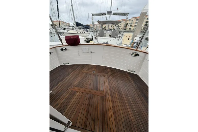 Slide: The Image of 2005 Kadey-Krogen 44 yacht deck with wooden flooring, docked at a marina. - 18
