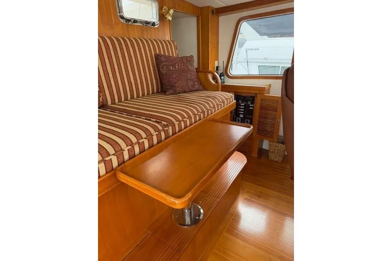 Slide: The Image of Interior of 2005 Kadey-Krogen 44 yacht with striped seating and wooden table. - 26