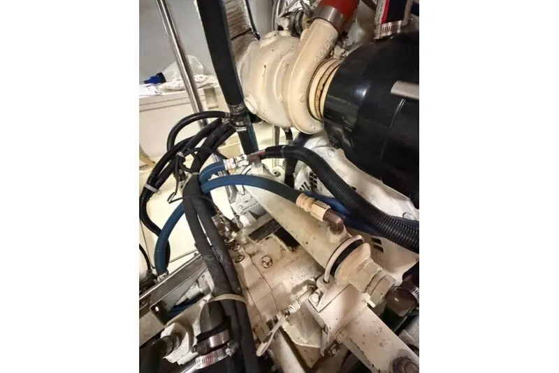 Slide: The Image of Engine components of a 2005 Kadey-Krogen 44 boat, featuring hoses and mechanical parts. - 57