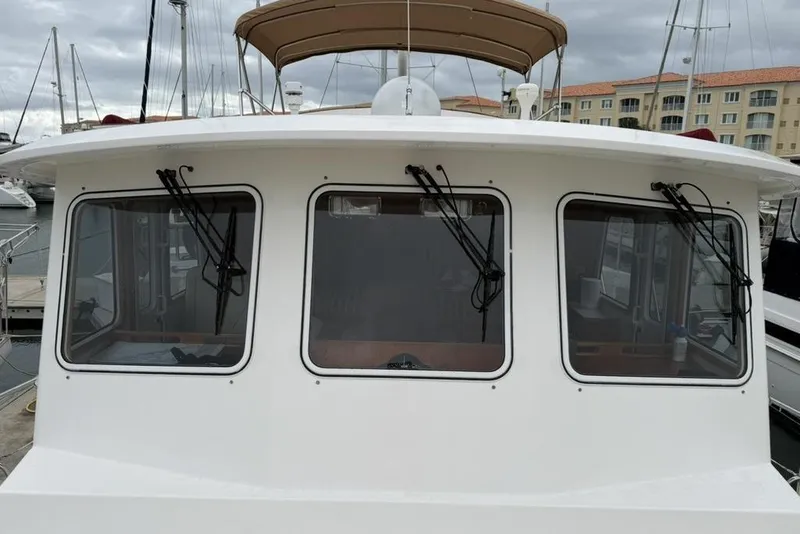 Slide: The Image of 2005 Kadey-Krogen 44 boat with three front windows and wipers at a marina. - 6