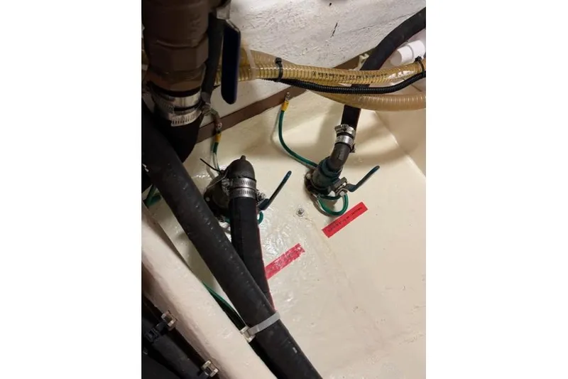 Slide: The Image of Engine room piping of a 2005 Kadey-Krogen 44 boat, featuring hoses and clamps. - 63