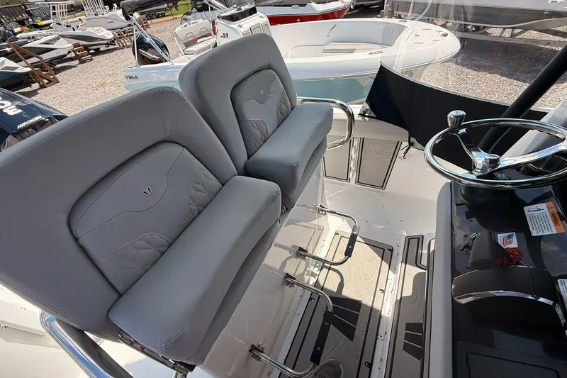 Slide: The Image of 2026 Wellcraft 243 Fisherman boat interior with dual seats and steering wheel. - 17