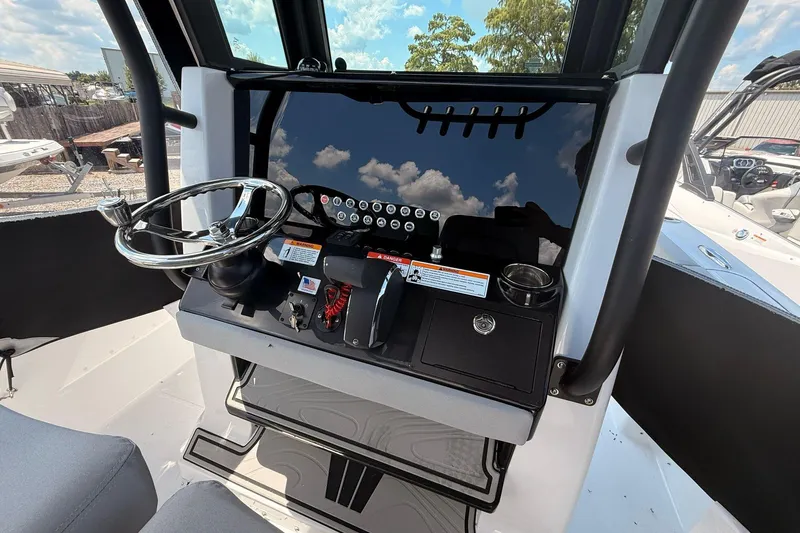 Slide: The Image of 2026 Wellcraft 243 Fisherman boat dashboard with steering wheel and control panel. - 19