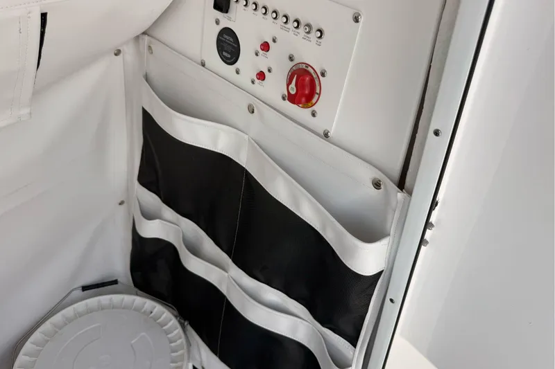 Slide: The Image of Control panel and storage on 2026 Wellcraft 243 Fisherman boat interior. - 29