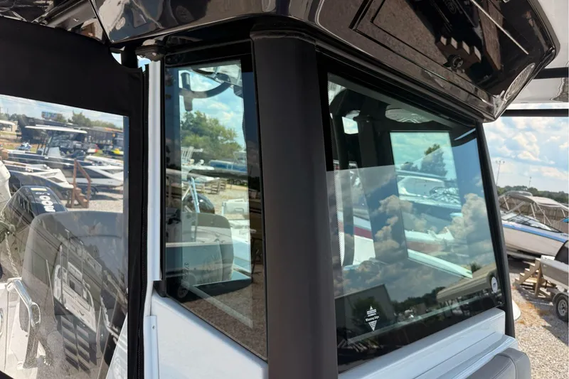 Slide: The Image of 2026 Wellcraft 243 Fisherman boat with reflective windows, showcasing marina surroundings. - 32