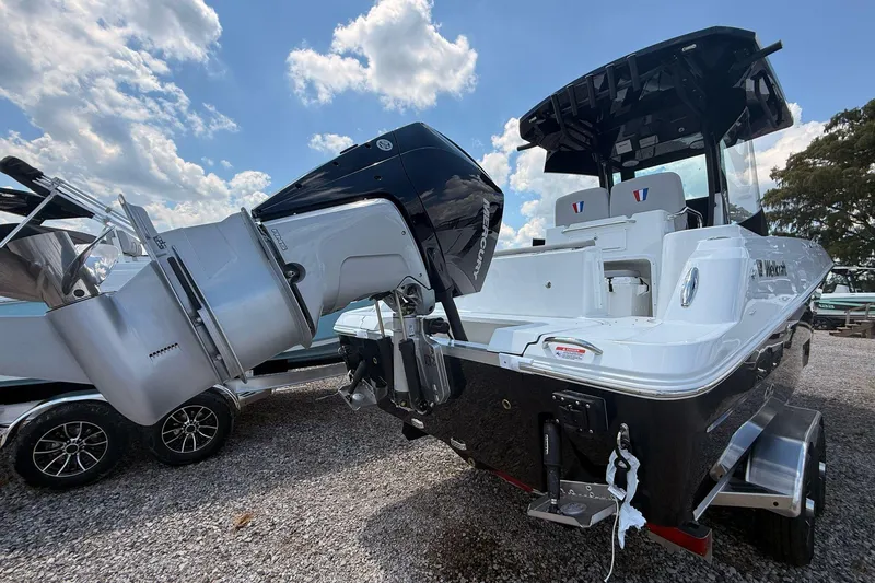 Slide: The Image of 2026 Wellcraft 243 Fisherman boat with powerful outboard motor, parked on gravel under a blue sky. - 4