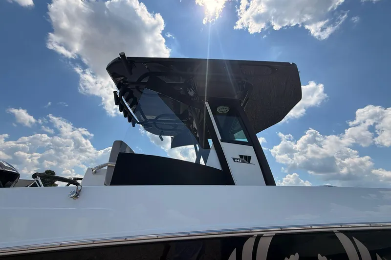 Slide: The Image of 2026 Wellcraft 243 Fisherman boat under a bright blue sky with clouds. - 8