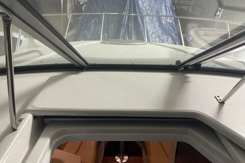 Slide: The Image of 2021 Crownline 264 CR boat interior with open hatch and windshield view. - 12