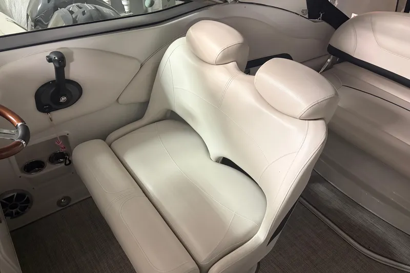 Slide: The Image of 2021 Crownline 264 CR boat interior with beige seating and steering controls. - 17