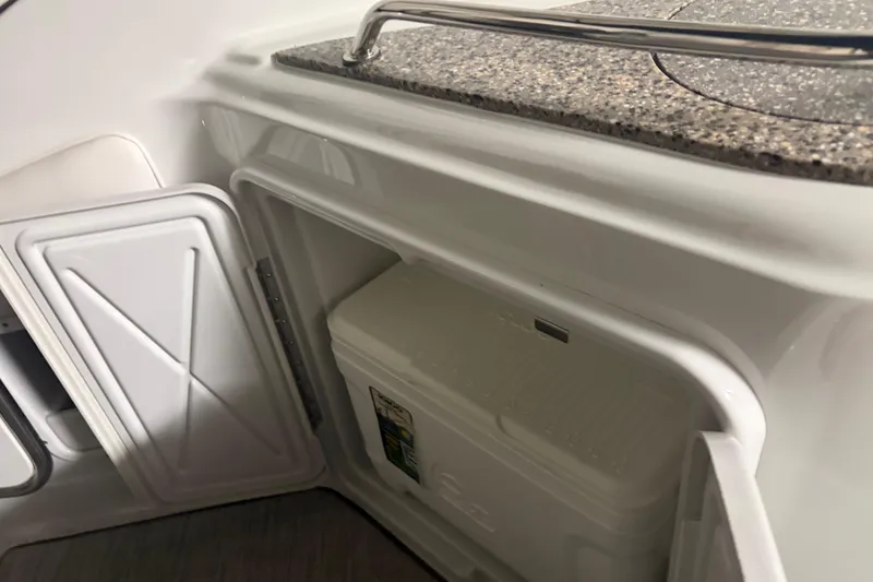 Slide: The Image of 2021 Crownline 264 CR boat interior with storage compartment and cooler. - 18