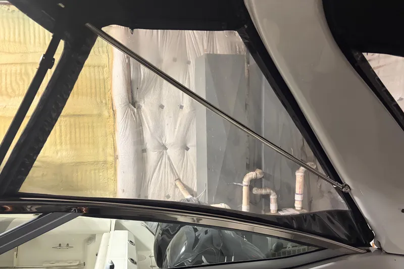 Slide: The Image of Interior view of a 2021 Crownline 264 CR boat with visible window and support rod. - 19