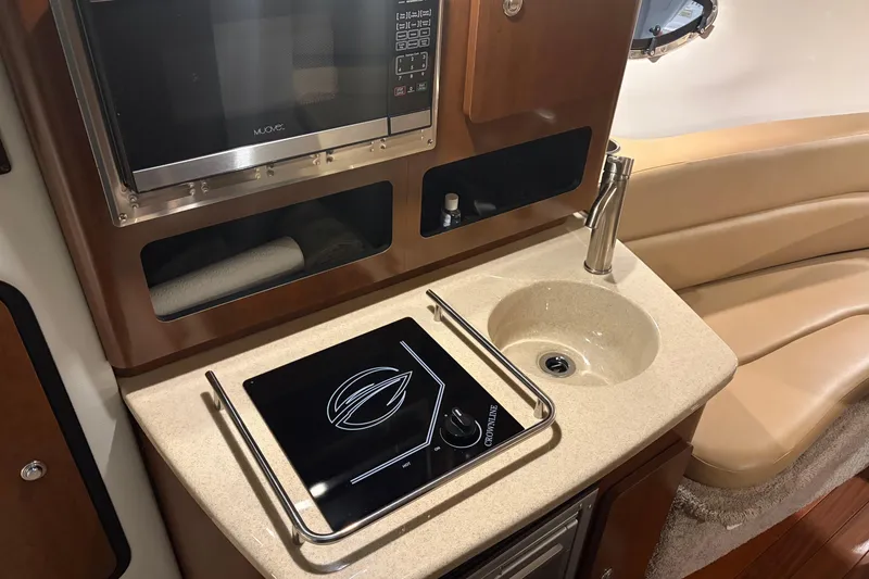 Slide: The Image of 2021 Crownline 264 CR boat interior with kitchenette, sink, and seating area. - 28