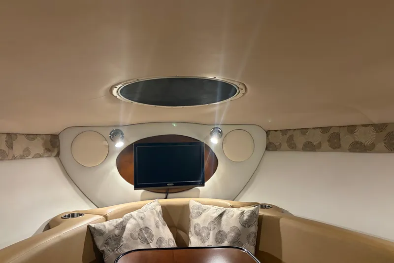 Slide: The Image of Interior of 2021 Crownline 264 CR boat with TV, seating, and decorative pillows. - 31