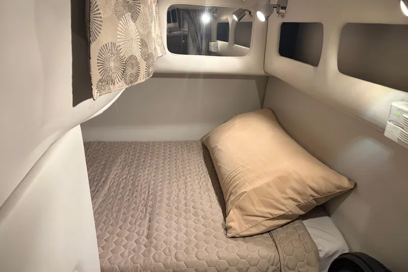 Slide: The Image of 2021 Crownline 264 CR cabin interior with cozy bed and modern lighting. - 32