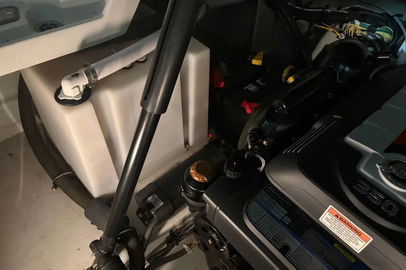 Slide: The Image of Engine compartment of a 2021 Crownline 264 CR boat, showcasing mechanical components. - 36