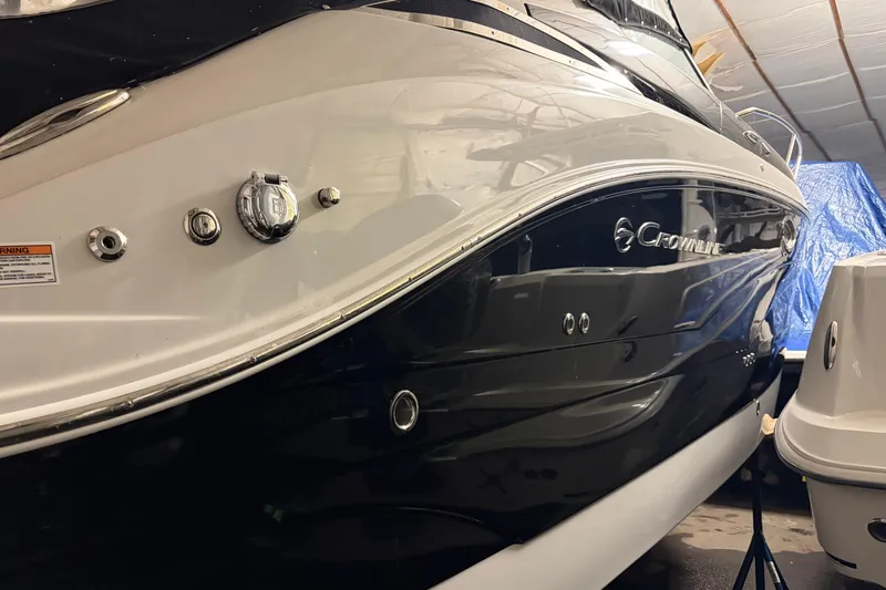 Slide: The Image of 2021 Crownline 264 CR boat in storage, showcasing sleek black and white design. - 8