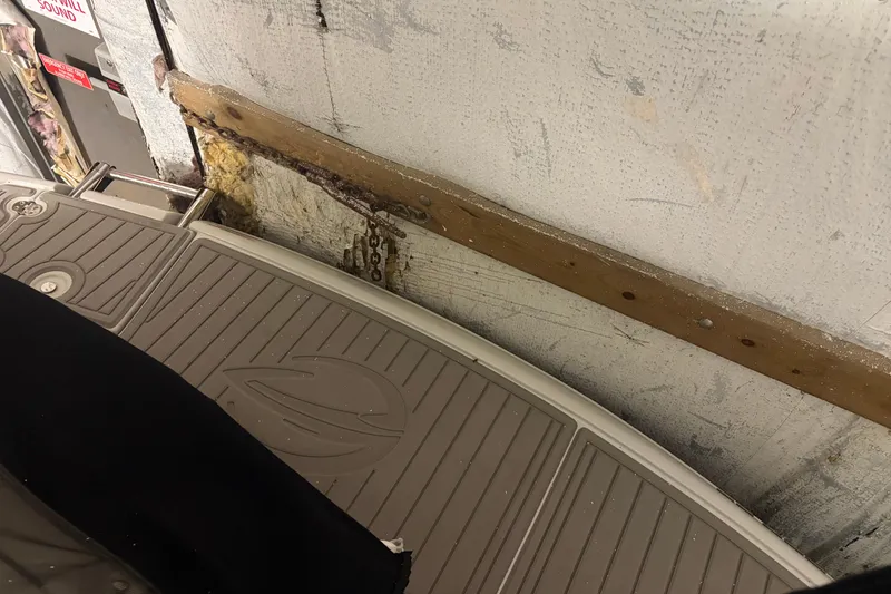 Slide: The Image of 2021 Crownline 264 CR boat detail in storage, showing deck and wall. - 9