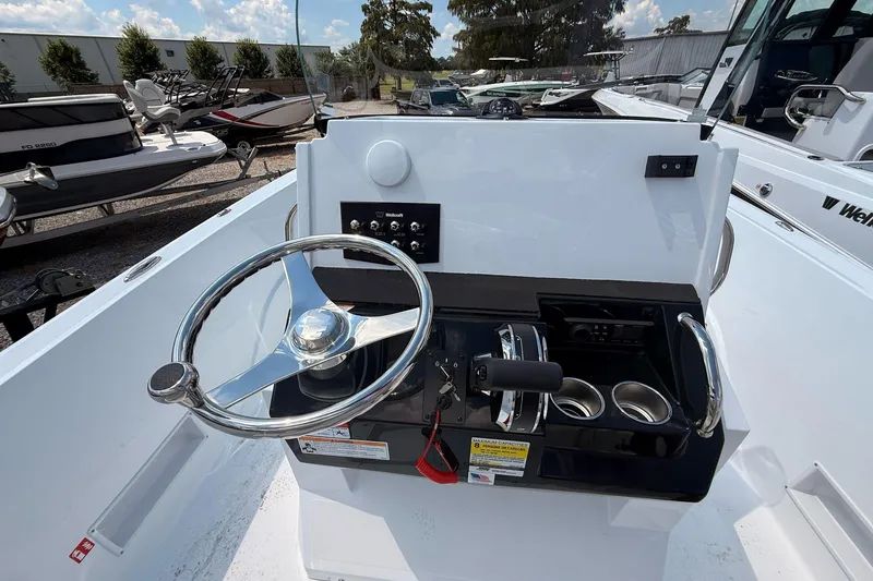 Slide: The Image of 2026 Wellcraft 202 Fisherman boat dashboard with steering wheel and controls. - 12