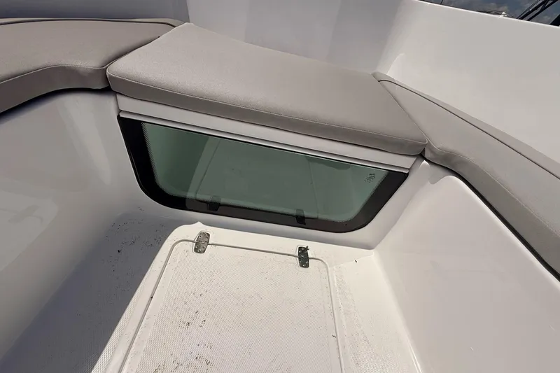 Slide: The Image of Interior seating of 2026 Wellcraft 202 Fisherman boat, featuring cushioned seats and storage compartment. - 16