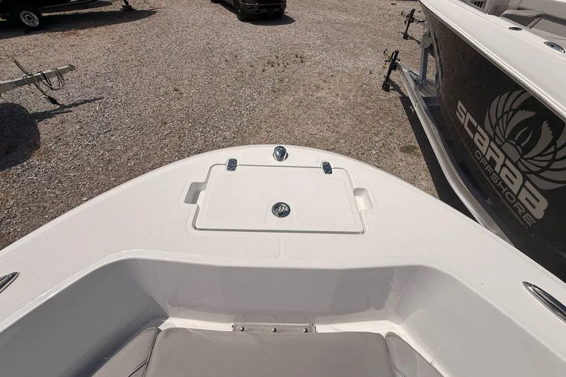 Slide: The Image of 2026 Wellcraft 202 Fisherman boat bow with storage compartment, parked on gravel. - 17